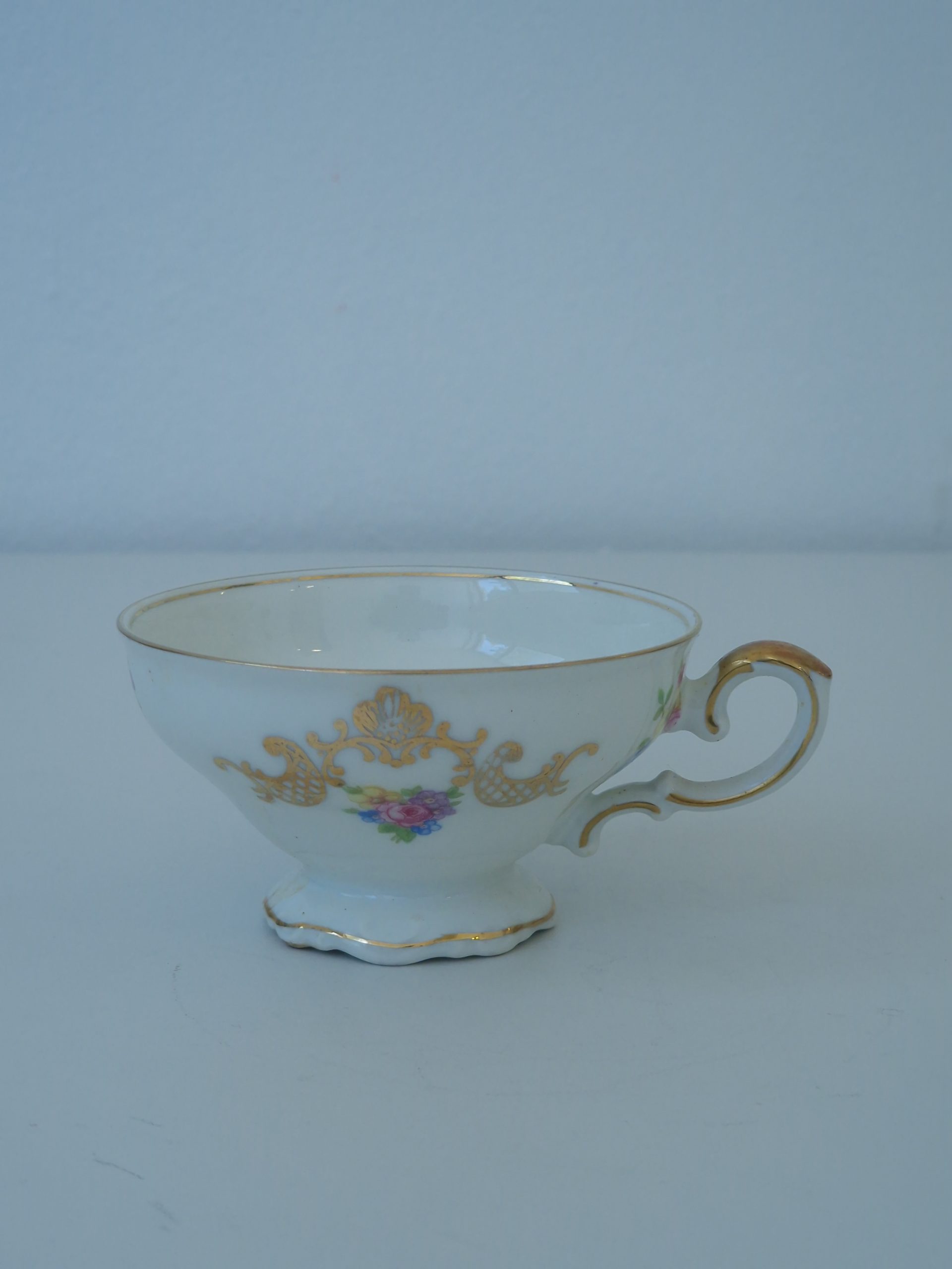 Antik kaffekopp med gulddekor och blomstermotiv